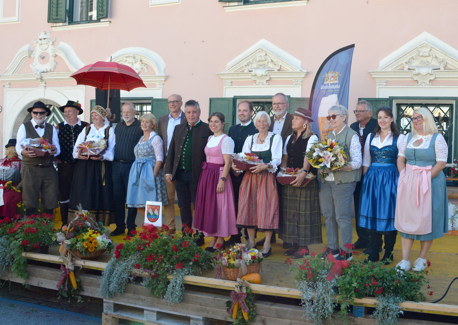 Delegation in Tracht mit Erntedankgaben auf einer Bühne in Bischofshofen